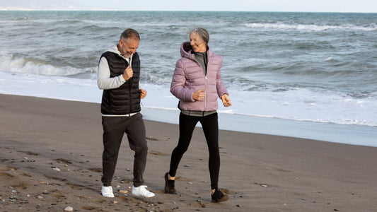 an older couple taking a brisk walk on the beach